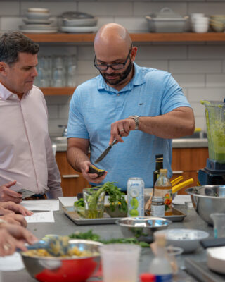 Male participant cutting an avocado open for a salad recipe in the nutrition theatre.